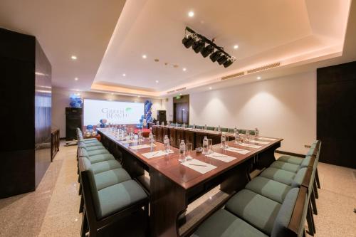 a long table in a room with chairs and a screen at Green Beach Hotel Nha Trang in Nha Trang
