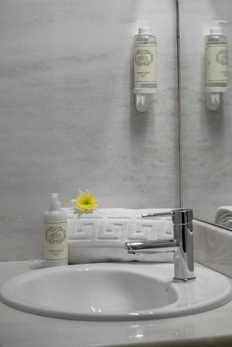 a bathroom sink with a bottle of soap and a soap dispenser at Hotel Estacão - Braga in Braga