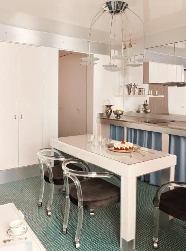 une cuisine blanche avec une table et des chaises blanches dans l'établissement Pied A Terre Arts et Métiers, à Paris