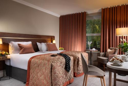 a hotel room with a bed and a desk and chair at Tulfarris Hotel and Golf Resort in Blessington