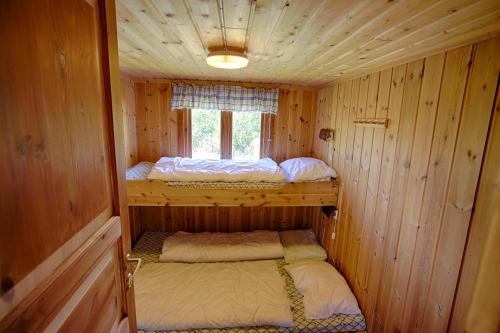 a small cabin with two beds in it at Charming Cabin with Old Timber, Fireplace & Views in Beitostøl