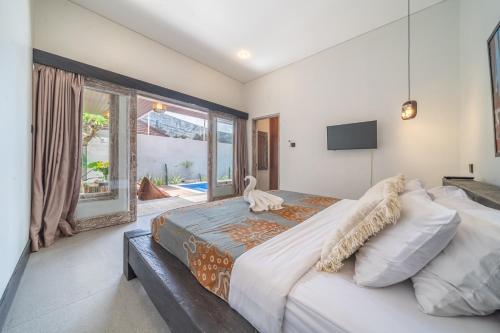 Un dormitorio con una cama grande y una ventana grande. en Villa Thyme, Private 2BR pool Villa, 2 minute walking to cafe, padel and tennis court, en Canggu