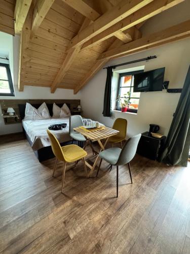 a bedroom with a bed and a table and chairs at Penzion Farma Žleby in České Žleby
