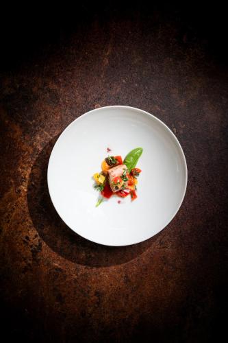 a white plate with food on top of a table at Hotel Frangart an der Weinstraße in Appiano sulla Strada del Vino
