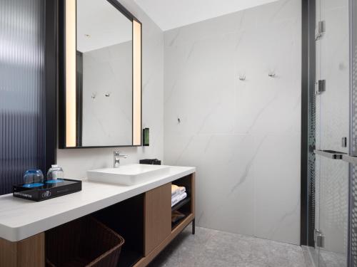 a bathroom with a sink and a mirror at Hampton by Hilton Dongguan Liaobu Songshan Lake Avenue in Liao-pu