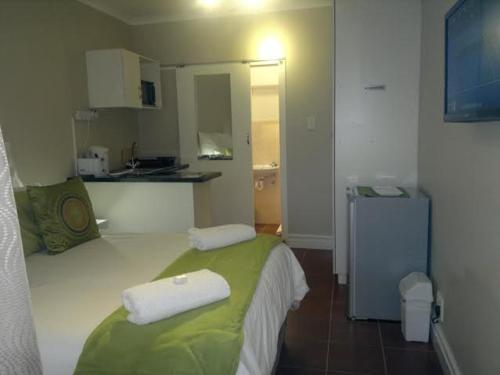 1 dormitorio con 1 cama con 2 toallas en 93 On Main Self Catering, en Gonubie