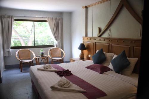 a bedroom with a large bed with two towels on it at Leng Hotel in Hua Hin