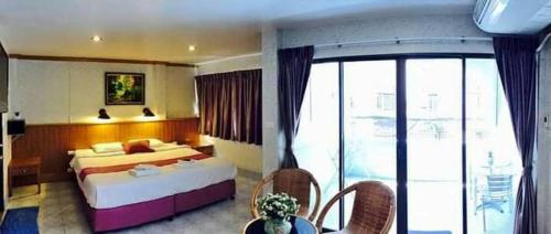 a hotel room with a bed and a balcony at Leng Hotel in Hua Hin