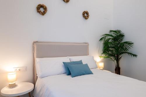 a bedroom with a white bed with two lamps and a plant at Main Lofts Valencia in Valencia