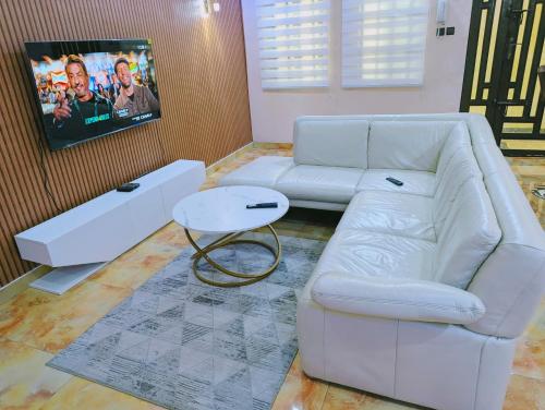 a living room with a white couch and a table at Domicile Cotonou in Cadjèhoun
