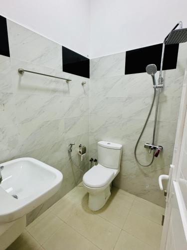 a bathroom with a toilet and a shower and a sink at Misty5 in Pattipola