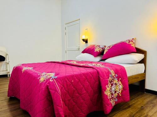 a bedroom with a bed with a pink blanket at Misty5 in Pattipola