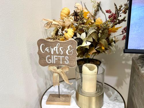 a table with a vase of flowers and a sign that says cards and gifts at Custom luxury house in Katy near I10 and 99 in Katy