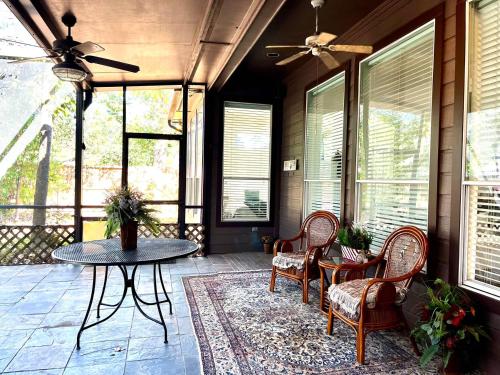 a porch with chairs and a table and a ceiling fan at Custom luxury house in Katy near I10 and 99 in Katy