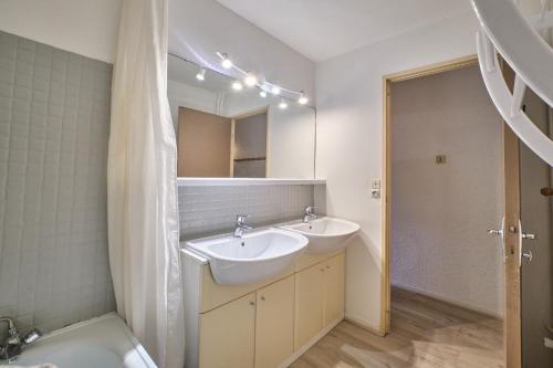 une salle de bain avec deux lavabos et un WC et un miroir dans l'établissement Meijotel, à Les Deux Alpes