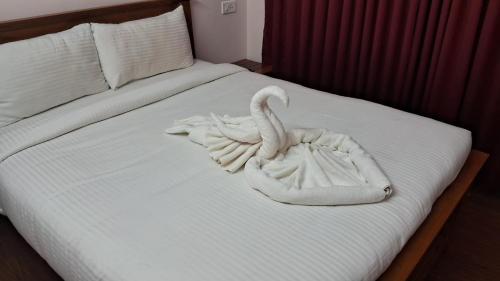 a swan made out of towels on a bed at Blissfull Meadows in Ooty