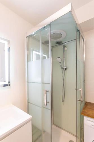 une douche avec une porte vitrée dans une salle de bain dans l'établissement A Deux Pas de la Magie - Idéal DisneyLand & Paris, à Bussy-Saint-Georges
