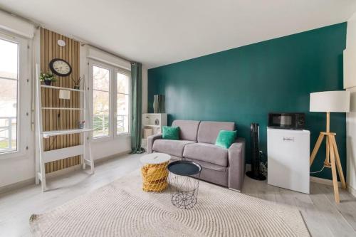 ein Wohnzimmer mit Sofa und Tisch in der Unterkunft A Deux Pas de la Magie - Idéal DisneyLand & Paris in Bussy-Saint-Georges