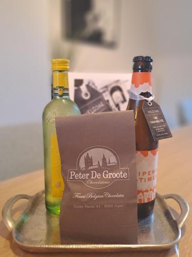 a tray with two bottles of wine and a box at The Carmelite in Ypres