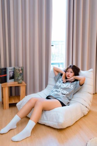 a woman laying on a bean bag chair at X-Stay in Hai Phong