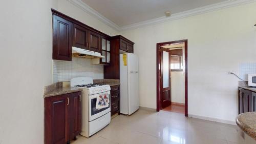 a kitchen with a stove and a refrigerator at Green Paradise in Juan Dolio