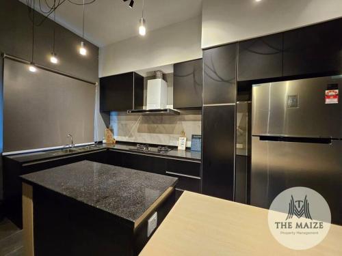 a kitchen with black cabinets and a black counter top at The Urban Lodge - Tasek Avenue Ipoh in Ipoh