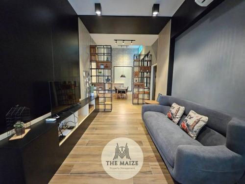 a living room with a blue couch and a table at The Urban Lodge - Tasek Avenue Ipoh in Ipoh