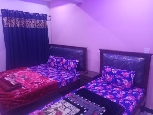 ein Zimmer mit zwei Betten und einem Vorhang in der Unterkunft Four Season Guest House in Islamabad