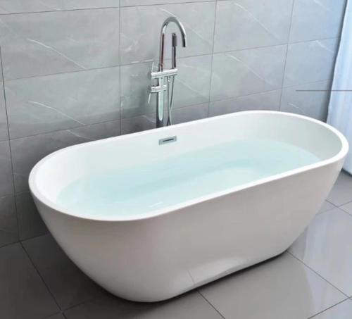 a white bath tub with a faucet in a bathroom at The Wing Boutique Hotel in Chiang Mai
