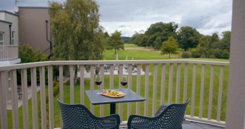 a table with two glasses of wine on a balcony at Tulfarris Hotel and Golf Resort in Blessington