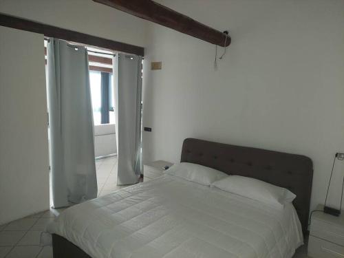 a bedroom with a white bed and an open door at Luminoso LOFT in centro a due passi da Lugo Imola in Massa Lombarda