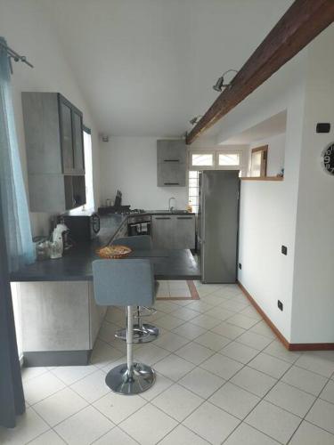 a kitchen with a counter and a chair in it at Luminoso LOFT in centro a due passi da Lugo Imola in Massa Lombarda
