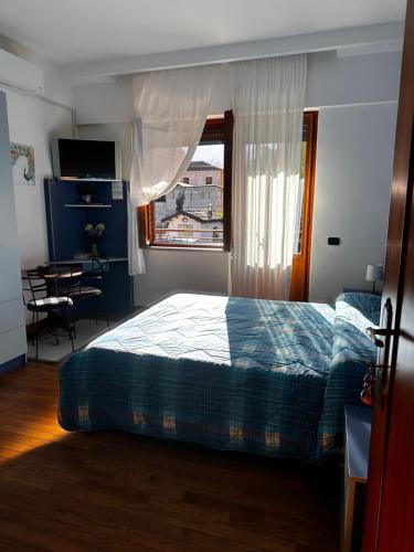 a bedroom with a bed and a desk and a window at B&B La Voliera in Sulmona