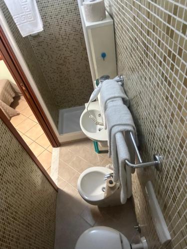 a bathroom with a toilet and a sink and a mirror at Hotel Svizzera in Arma di Taggia