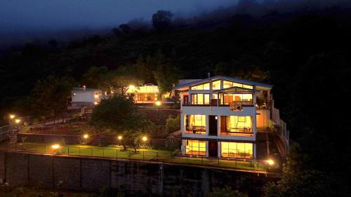 a large house on top of a hill at night at Par-X - Villa Sukoon - 3BHK Valley View - Leave the World Far Behind in Satara