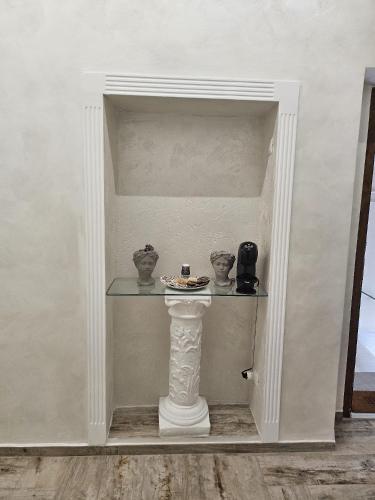 a shelf with vases on a pillar in a room at Le Stanze di Giulia in Melfi