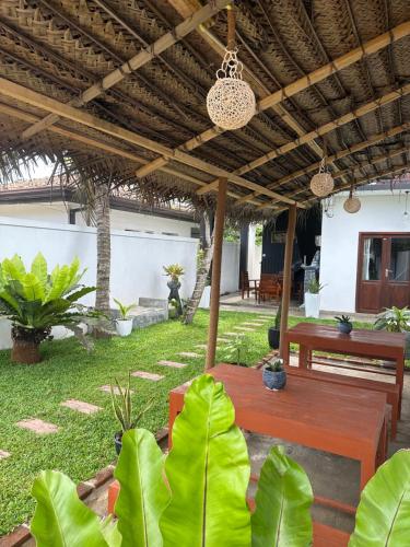 a patio with a table and benches and plants at Surf Heavens in Dickwella