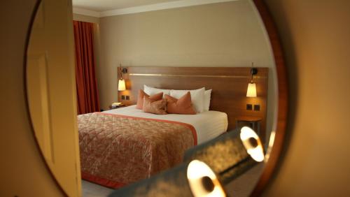 a hotel room with a bed and a mirror at Tulfarris Hotel and Golf Resort in Blessington