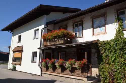 ein weißes Gebäude mit Blumenkästen an den Fenstern in der Unterkunft Haus Sennweg in Tannheim