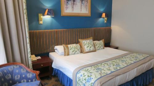 a bedroom with a bed in a blue room at London Lodge Hotel in London