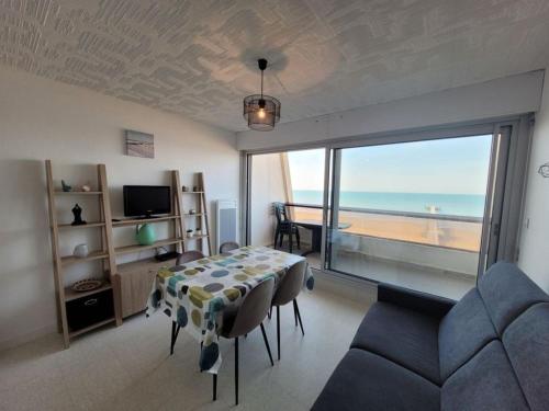 - un salon avec une table et une vue sur l'océan dans l'établissement Très bel appartement accès direct sur plage, vue sur mer - 2 pièces - 4 pers, à Saint-Jean-de-Monts