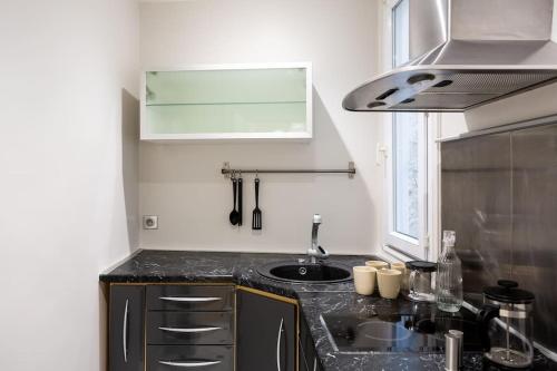 une cuisine avec un évier et un plan de travail dans l'établissement La Suite des Expositions, à Paris