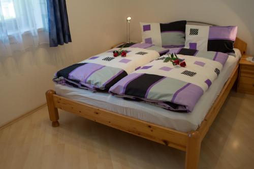 a bedroom with two beds with purple and white comforters at Ferienwohnung Biechl-Hauser Doris in Sankt Ulrich am Pillersee