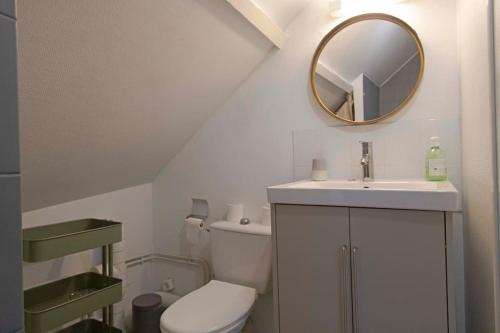 une salle de bain blanche avec un lavabo et un miroir dans l'établissement La haute république, à Brive-la-Gaillarde