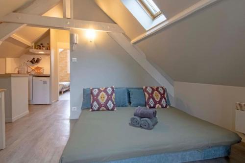 Cette chambre mansardée comprend un grand lit. dans l'établissement La haute république, à Brive-la-Gaillarde