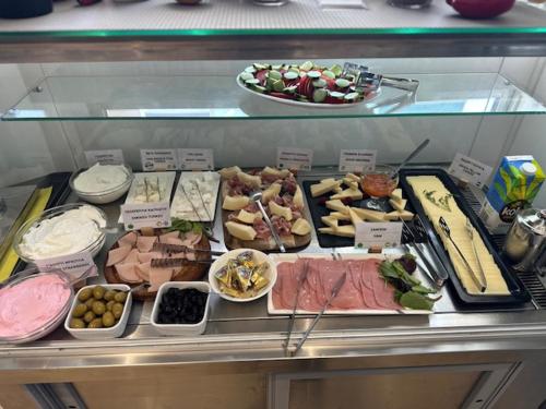 a display case with many different types of food at Meliton Inn Hotel & Suites by the beach in Neos Marmaras