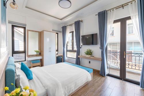 a bedroom with a large bed with blue curtains at VMT Hotel Da Lat in Da Lat