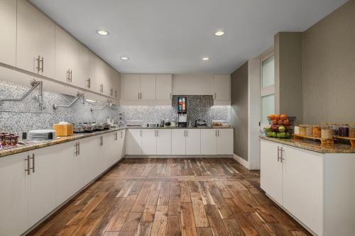 a large kitchen with white cabinets and wooden floors at Residence Inn by Marriott Long Island Islip/Courthouse Complex in Central Islip
