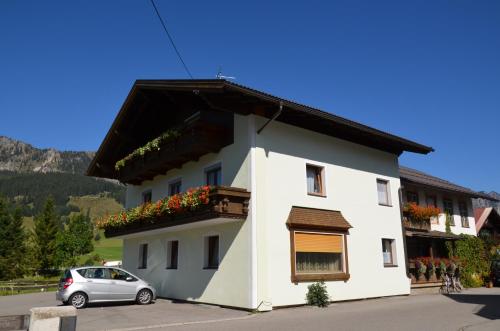 a white house with a car parked in front of it at Haus Sennweg in Tannheim