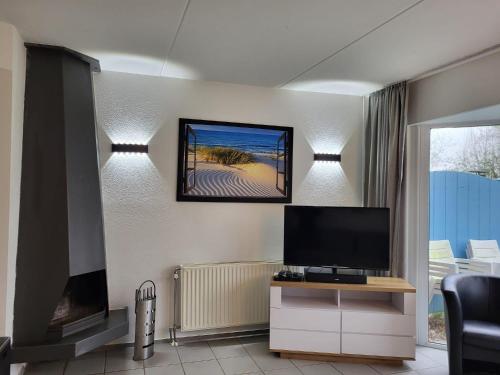 a living room with a flat screen tv and a flat screen tv at Ferienhaus Seeperle in Tossenserdeich